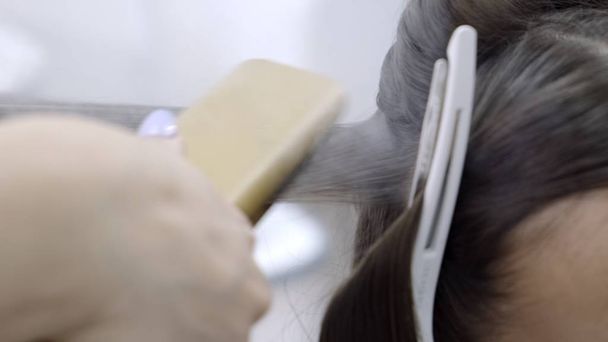 Fryzjerstwo ma laminowanie i prostowanie włosów w salonie piękności dla dziewczynki z brązowymi włosami. koncepcja pielęgnacji włosów - Zdjęcie, obraz
