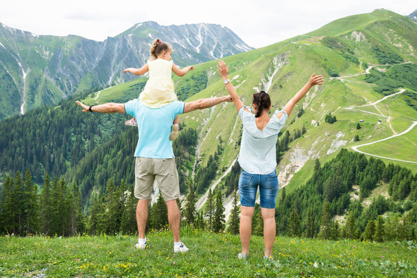 Rear View Of Happy Family Looking At Panoramic Mountain View - 写真・画像