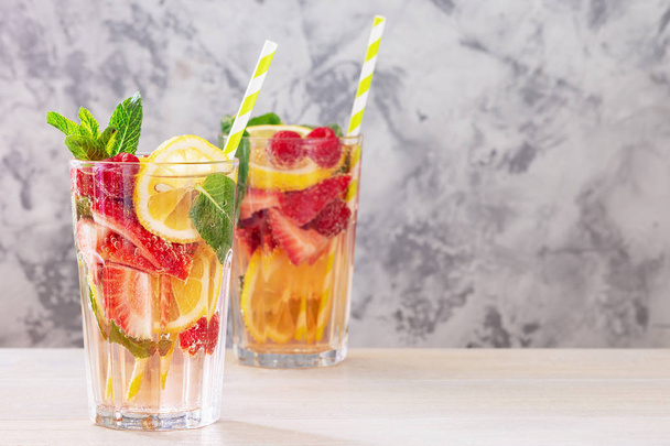 Deux verres à la limonade de citron, fraise, framboise et menthe. Boisson saine fraîche. Photo avec espace pour le texte
. - Photo, image