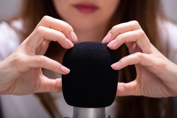 Woman scratching microphone with nails to make ASMR sounds - Foto, immagini