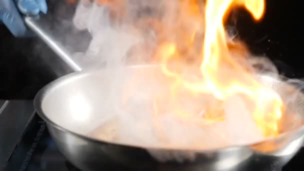 Tanınmaz aşçı deniz ürünleri ile sıcak yapışmaz kızartma tavası atarak, sonra yangın flambe çanak pişirme ayarı. Yavaş çekim foodvideo görüntüleri. Hd - Video, Çekim