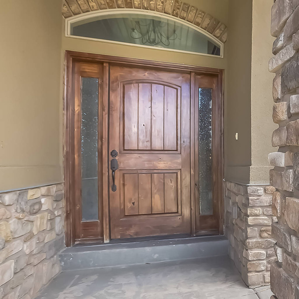 Square frame Home facade with brown wood door frosted sidelights and arched transom window - Photo, Image