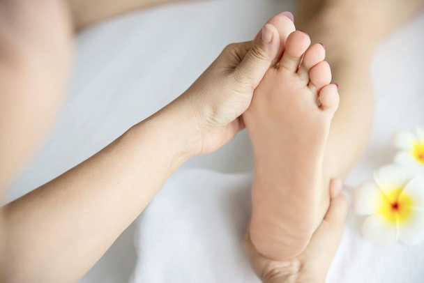 Frau erhält Fußmassage-Service von Masseurin aus nächster Nähe an Hand und Fuß - entspannen Sie sich im Konzept der Fußmassage-Therapie - Foto, Bild