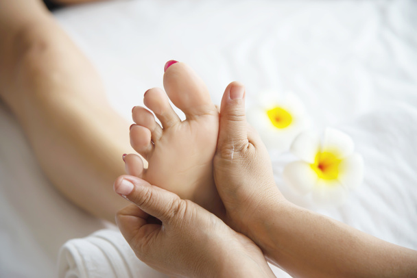 Frau erhält Fußmassage-Service von Masseurin aus nächster Nähe an Hand und Fuß - entspannen Sie sich im Konzept der Fußmassage-Therapie - Foto, Bild