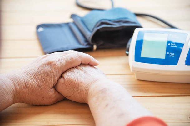 Old lady is being checked blood pressure using blood pressure monitor kid set - people with health care medical instrument set concept - Photo, image