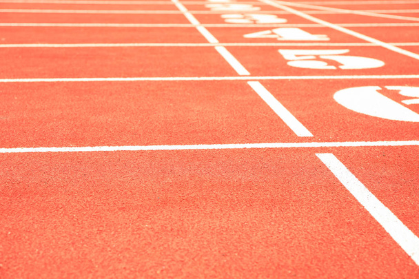 Start of red athletic track with numbers, space for text - 写真・画像