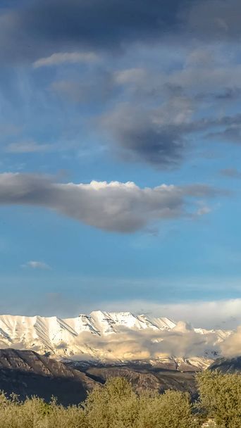 Bulutlu mavi gökyüzü altında görkemli kar tepeli dağ ile Dikey Manzara doğa görünümü - Fotoğraf, Görsel
