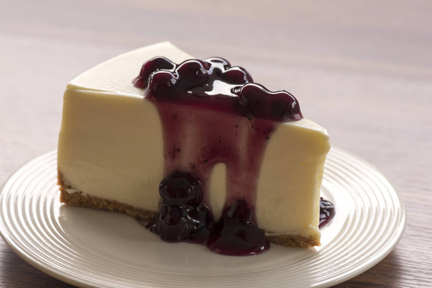 Blueberry cream cheesecake in white plate on wood table - Photo, Image