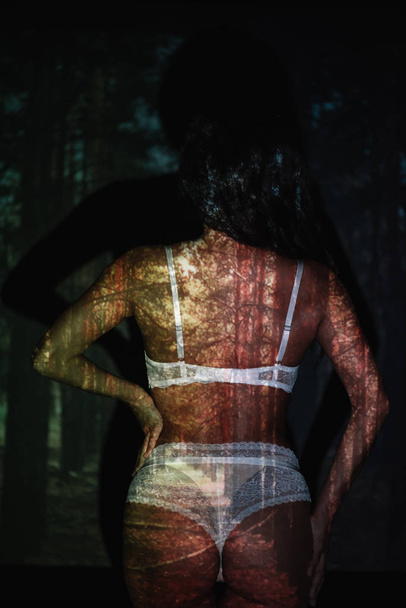 вид сзади на сексуальную девушку, стоящую в кружевном белом белье рядом с деревьями
  - Фото, изображение