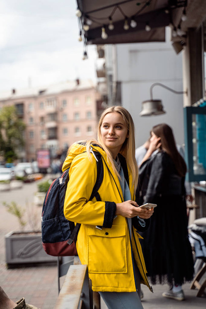 Nainen kävelee ja käyttää älypuhelinta kadulla - Valokuva, kuva
