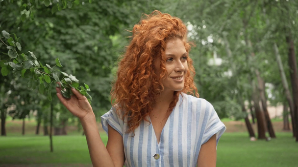 parkta yürüyen kızıl saçlı kızın seçici odak noktası  - Video, Çekim