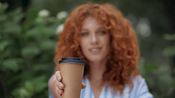 Focus pull de joyeuse rousse fille tenant tasse en papier
  - Séquence, vidéo