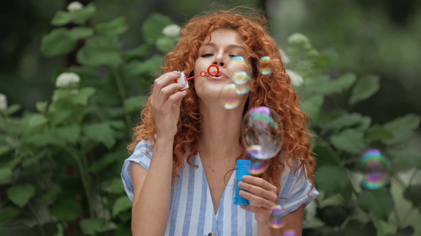 glücklich Rotschopf Mädchen pustet Seifenblasen  - Filmmaterial, Video