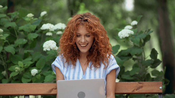 szczęśliwy rudowłosy kobieta mający wideo rozmowa w Park  - Materiał filmowy, wideo