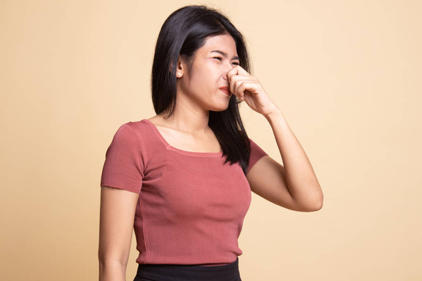 Young Asian woman  holding her nose because of a bad smell. - Fotó, kép