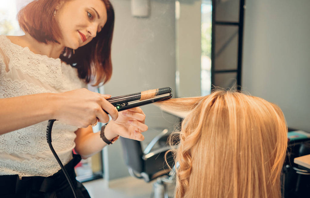 coiffeuse féminine coiffant une belle blonde
 - Photo, image