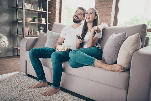 Amazing pair holding plate with popcorn watch favorite humorous show sitting sofa indoors - Fotoğraf, Görsel
