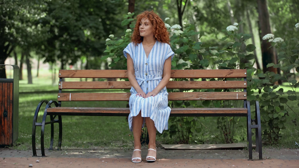 привлекательная девушка ждет на скамейке в парке
  - Кадры, видео