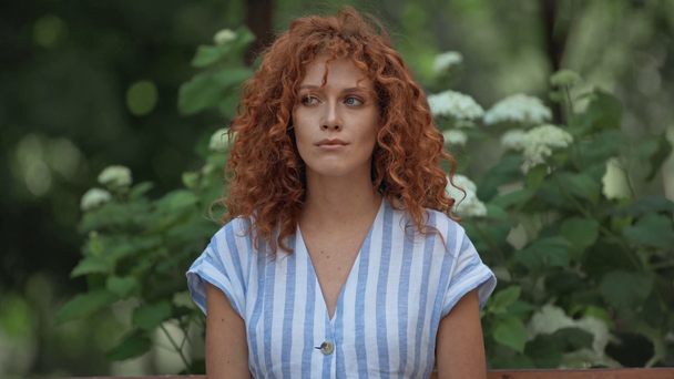 displeased redhead girl standing in green park  - Imágenes, Vídeo