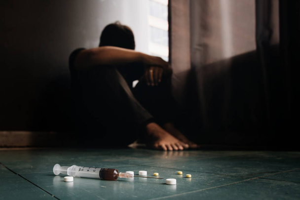 Conceptual image on the subject of drug addiction.man sitting an - Foto, Imagem