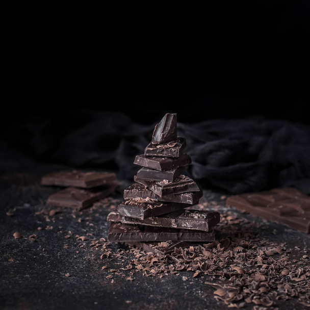 Dark chocolate with chocolate chips on dark background - Фото, изображение