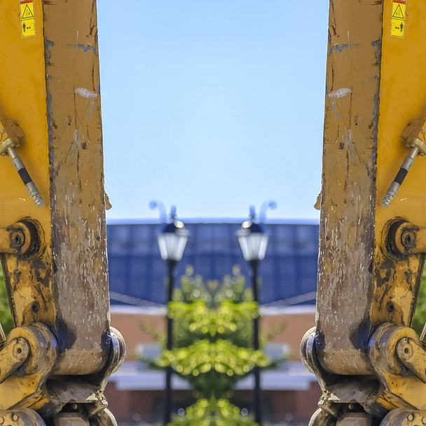 Quadrato Doppia visuale di un braccio trattore giallo verticale
 - Foto, immagini