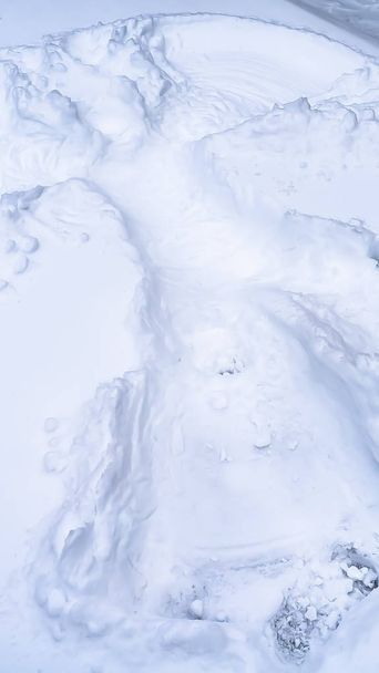Vertical Vista de perto de um anjo da neve criado no chão coberto de neve no inverno
 - Foto, Imagem