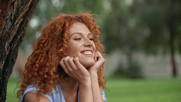 χαρούμενο κοκκινομάλλα κορίτσι κοιτάζοντας φυσαλίδες σαπούνι  - Πλάνα, βίντεο