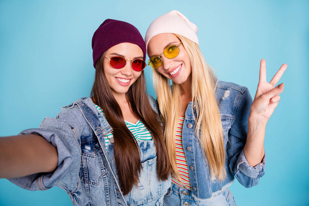 Self-portrait of nice-looking attractive lovely lovable sweet funky cheerful cheery girls having fun showing v-sign holiday isolated over bright vivid shine blue green turquoise background - 写真・画像