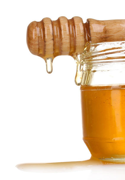 Jar of honey and wooden drizzler isolated on white - 写真・画像