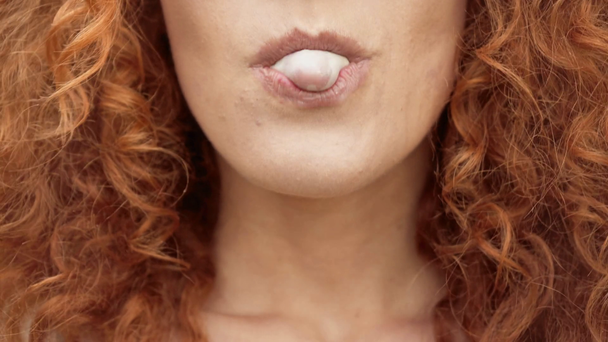przycięte widok kręcone kobieta dmuchanie gumy Bubble  - Materiał filmowy, wideo