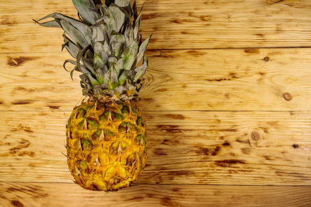 Whole pineapple on wooden table. Top view, copy space - Photo, Image