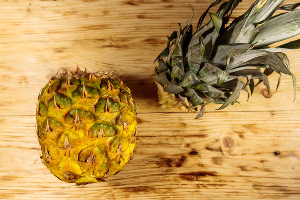 Liści i owoców ananasa na drewnianym stole. Widok z góry - Zdjęcie, obraz