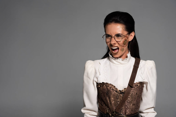 angry steampunk woman in white blouse screaming isolated on grey - Photo, Image