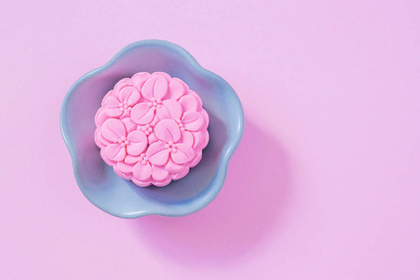 Pink mooncake, blue teapot, cup of green tea on a pink background. Chinese mid-autumn festival food. - Foto, Bild