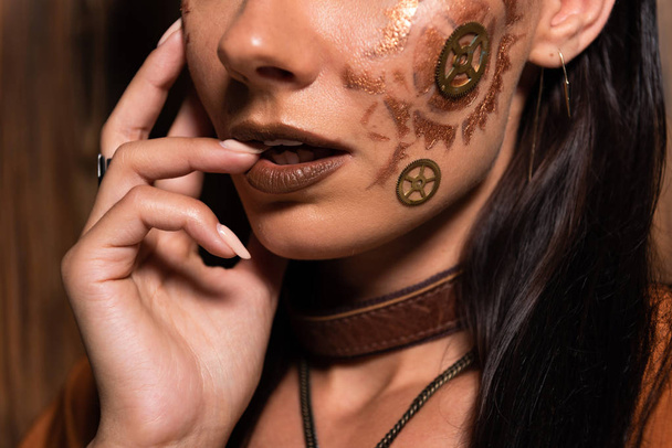cropped view of woman with steampunk makeup on brown - Fotó, kép