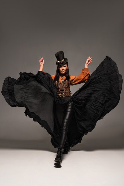 pełny widok długości atrakcyjne steampunk Kobieta w Top Hat z goglami na szarym - Zdjęcie, obraz
