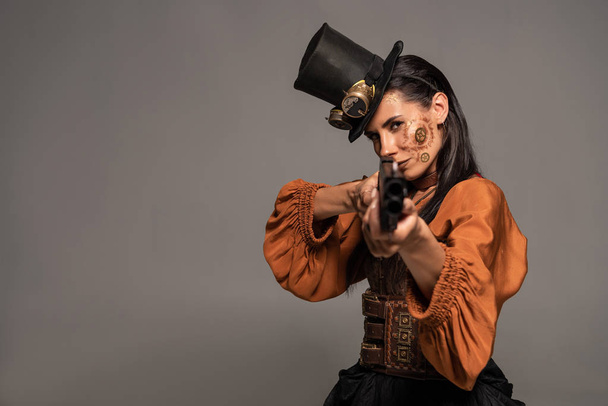 fókuszált Steampunk nő cilinder, amelynek célja a fegyvert izolált szürke - Fotó, kép