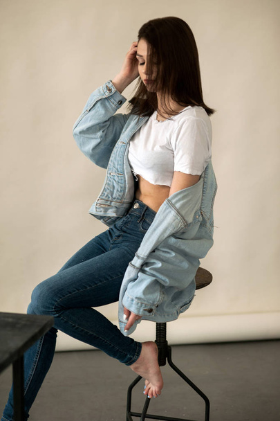 girl in white T-shirt and denim over background - Photo, Image