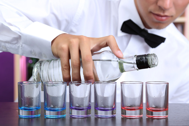 Bartender is pouring vodka into glasses - Zdjęcie, obraz
