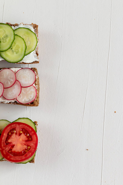 Здоровые вкусные бутерброды с ржаным хлебом и сезонными овощами и творогом на завтрак. С пробелами для текста
 - Фото, изображение