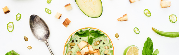 plan panoramique de délicieuse soupe de légumes vert crémeux avec cuillère en argent isolé sur blanc
 - Photo, image