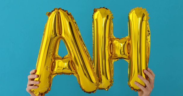 Palabra AH de oro hecha de globos inflables
 - Foto, Imagen