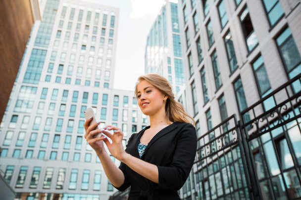 beautiful young woman in a suit with a phone in her hands - Foto, afbeelding
