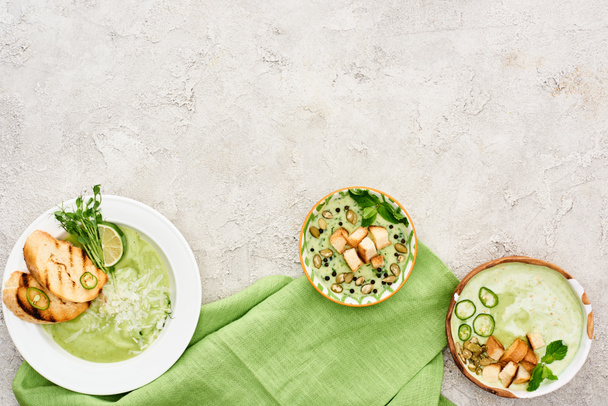 vista superior de la deliciosa sopa verde cremosa servida con croutons en servilleta verde
 - Foto, Imagen