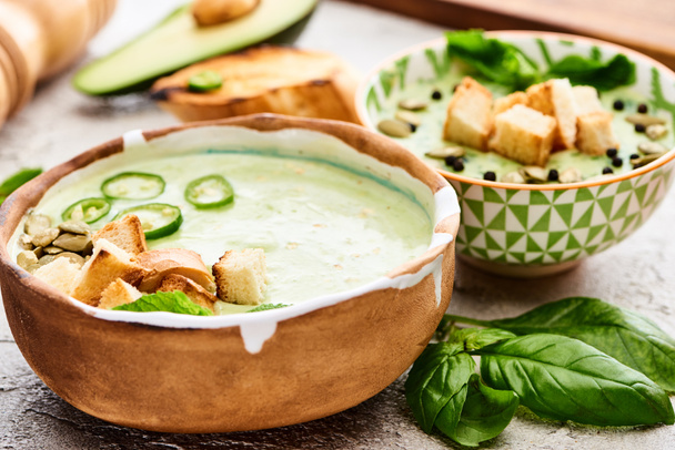 bowls with delicious green vegetable creamy soup with croutons - Photo, Image