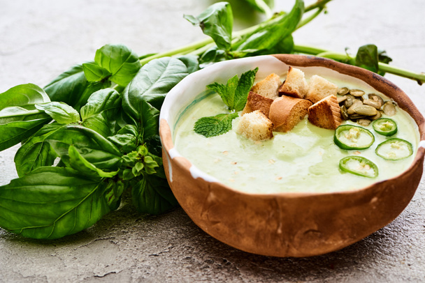 tazón de deliciosa sopa cremosa de espinacas verdes con croutons, jalapeños y semillas de calabaza
 - Foto, Imagen