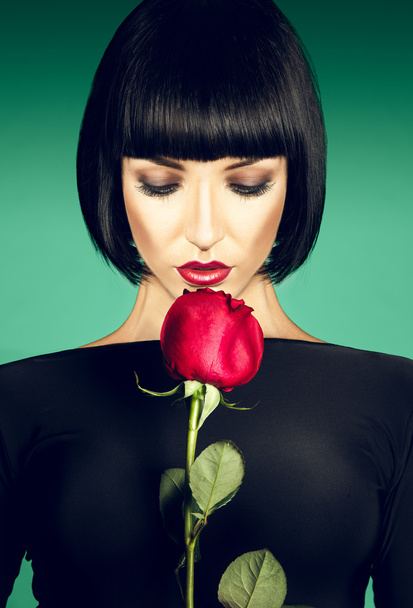 Charming brunette with der rose on green background - Photo, Image