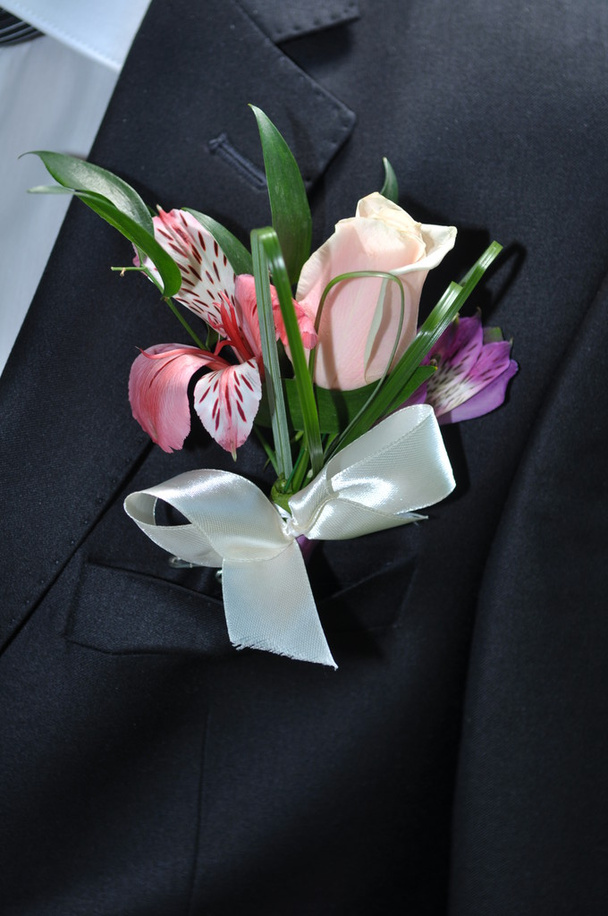 Close up of grooms black suit and colorful buttonhole - Photo, Image
