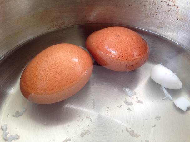 Paslanmaz tencerede haşlanmış yumurta. Tencereye iki yumurta yerleştirilir. - Fotoğraf, Görsel